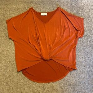 Rust/faded red color, super soft, has knot in front